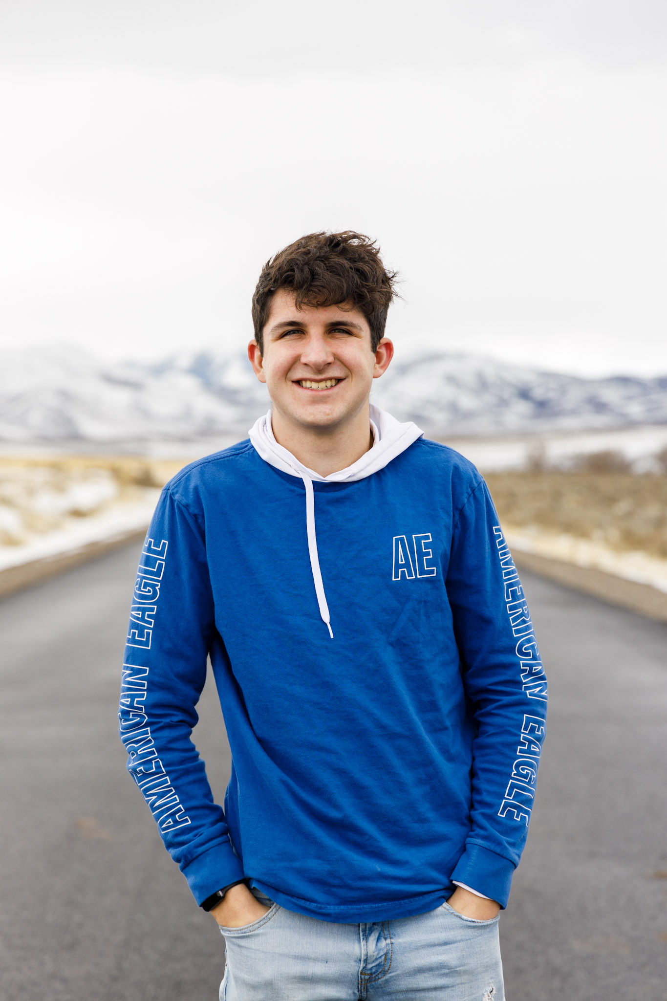 Senior photo, in the road with mountains behind